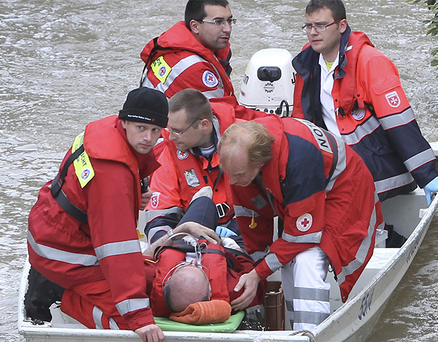 Person wird von Mitarbeitern des BRK mit einem Boot gerettet