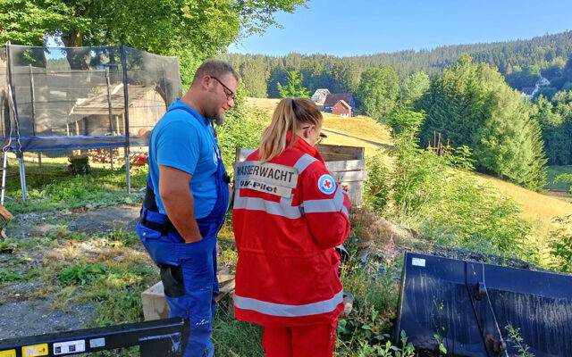 Drohnen-Pilotin der Wasserwacht bei Briefing vor Überflug eines zu mähenden Feldes - gesucht werden Rehkitze, die sich im Feld verstecken.