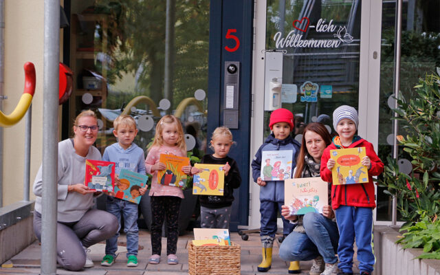 Kinder des BRK-Kinderhauses und des BRK-Kindernestes in Bayreuth präsentieren die mehrsprachigen Bücher - angeschafft durch das BRK im Rahmen der inländischen Ukraine Hilfe - unterstützt von der BMW-Group.