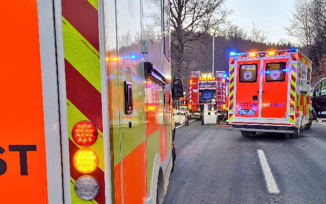 Einsatzkräfte des BRKs am Einsatzort auf der B 303 mit Blaulicht.