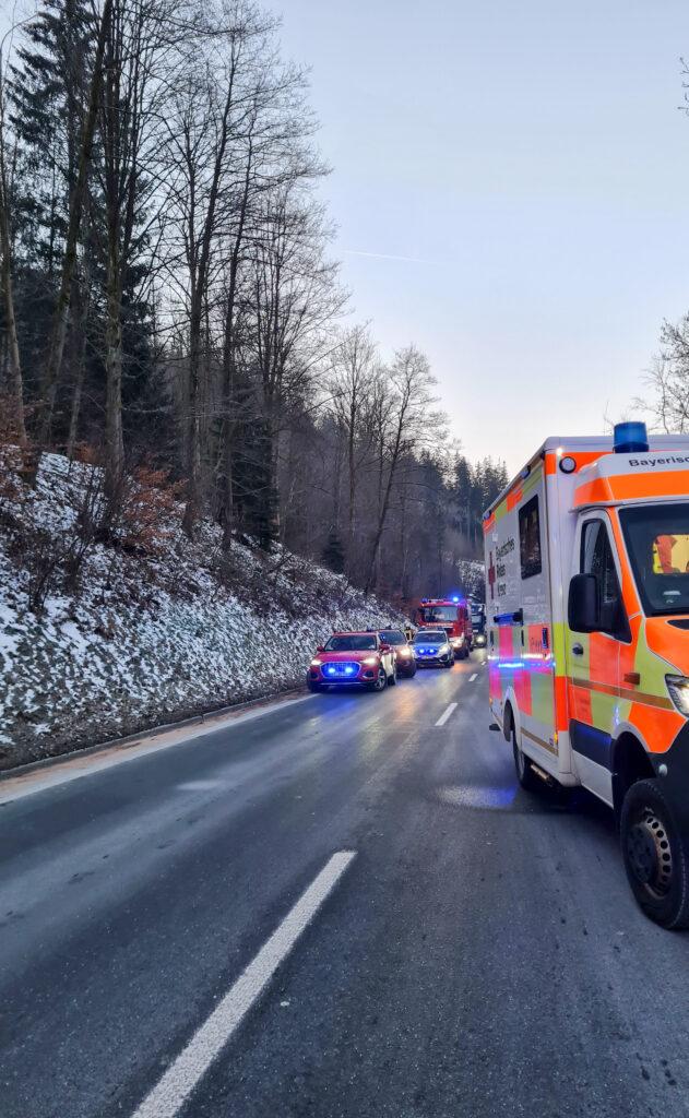 Einsatzkräfte des BRKs am Einsatzort auf der B 303 mit Blaulicht.