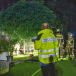 Einsatzkräfte am Einsatzort in Konnerreuth. Feurewehrleute mit Löschen Brand in einer Gartenanlage.