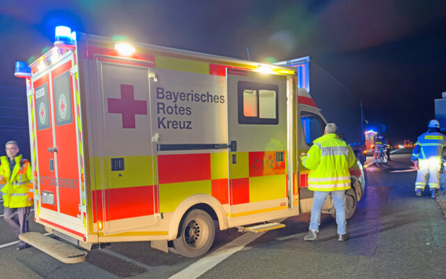 EInsatzkräfte des BRK-Rettungsdienstes mit Rettungswagen an der Einsatzstelle auf der A9.