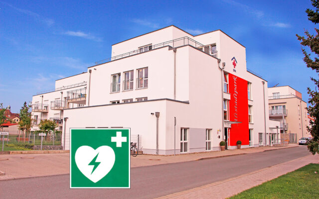 Fronstansicht des BRK-Altstadtparks im Bayreuther Eichelweg. kombiniert mit dem gänigen Hinwieschild für einen Defibrillator (Weißes Herz mit grünem Blitz auf grünem Feld. In der rechten Ecke, oben eine weisse Kreuz).