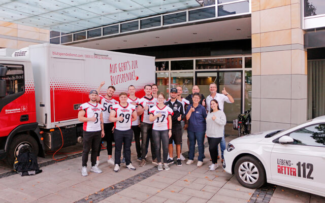 Das Bild zeigt die Spieler der Bayreuth Dragons American-Football-Mannschaft bei ihrem Engagement für die Blutspende und das Team der Blutspende des BRK-Kreisverbandes Bayreuth.