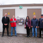 Untestützer und Bürgermsiterin Sybille Pichl stehen vor neuer Notfallsation in der Donndorfer Wilhelminenstraße. Im Bild (v.l.n.r.): Marcus Rasp (Sparkasse Bayreuth – stv. Regionaldirektor Marktgebiet Bayreuth-Land), Karl Bernet (ehrenamtlicher BRK-Projektkoordinator Defi-Netzwerk Bayreuth), Sybille Pichl (Bürgermeisterin Eckersdorf), Manfred Franke (Donndorfer Siedlergemeinschaft) und Helmut Zeitler (1. Kommandant Feuerwehr Donndorf).