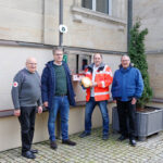 Inbetriebnahme des öffetnlich-zugänglichen Defibrillators vor dem Bad Bernecker Rathaus. Im Bild: Hermann Maier (BRK-Ausbilder), Bernhard Leutheusser (Geschäftsführer Hartsteinwerke Schicker), Karl Bernet (Projektkoordinator Defi-Netzwerk Bayreuth) und Jürgen Zinnert (Bürgermeister Bad Berneck).