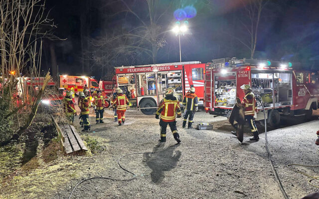 Einsatzkräfte der Feuerwehr mit Einsatzfahrzeugen am Einsatzort.