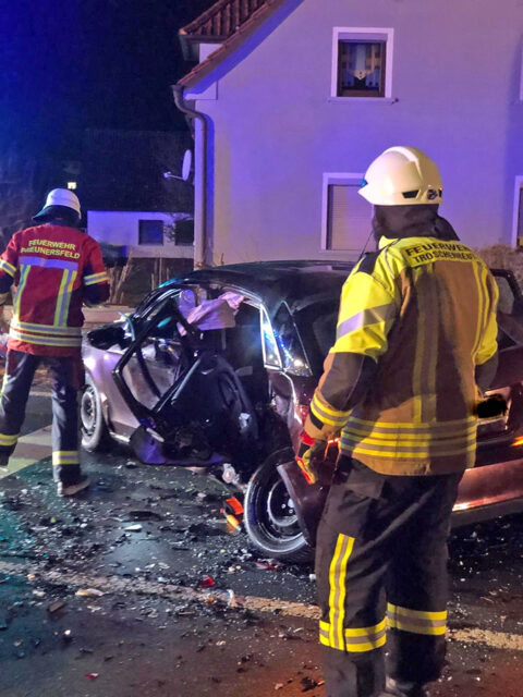 Einsatzkräfte der Feuerwerh an einem Unfallwagen.