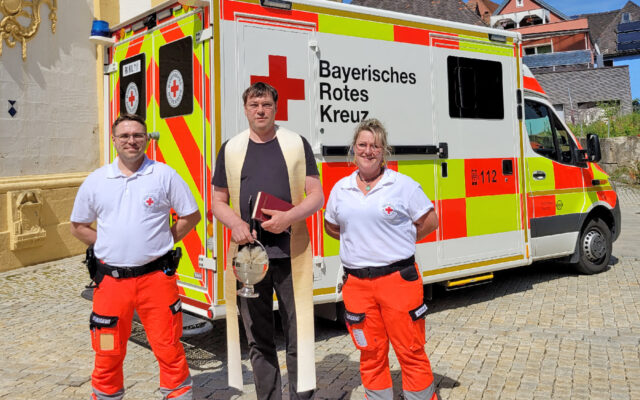 Im Bild: Pfarrer Hans-Jürgen Wiedow und Sanitäter der BRK-Rettungswache Hollfeld.