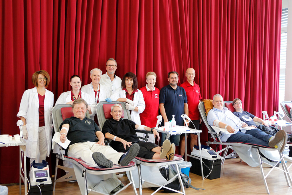 25 Musikerinnen und Musiker des Bayreuther Festspielorchesters engagierten sich zusammen mit Konzertmeister Juraj Cizmarovic und Orchestervorstand Matthias Höfer für die Blutspende und leisteten ihren Beitrag für die Aufrechterhaltung der medizinischen Versorgung. Im Bild: Ehrenamtliche Blutspendehelferinnen und Blutspendehelfern des BRK-Kreisverbandes Bayreuth um Ehrenamtskoordinator Florian Förster, Matthias Freund (Gebietsreferent des Blutspendedienstes des Bayerischen Roten Kreuzes – BSD) mit dem Team des BSDs, Musikerinnen und Musikern des Bayreuther Festspielorchesters um Konzertmeister Juraj Cizmarovic und Orchestervorstand Matthias Höfer. Foto: Tobias Schif / BRK-Bayreuth.