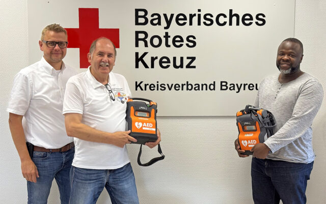 Seit 30 Jahren engagiert sich der BRK-Kreisverband Bayreuth für die Förderung der Kenntnisse der Bevölkerung in der Frühdefibrillation - in der Heimat und nun auch international. Das Projekt der Integrierten Leitstelle (ILS) Bayreuth/Kulmbach übergibt zwei Automatische Elektrische Defibrillatoren (AED) an Integrationsbeauftragter der Stadt Bayreuth Ibukun Koussemou (r.), für Krankenhäuser in Benin. Seit 20 Jahren engagiert sich der BRK-Kreisverband Bayreuth in Sachen Frühdefibrillation Im Bild (vl.n.r.): Markus Ruckdeschel (Kreisgeschäftsführer BRK-Bayreuth), Karl Bernet (ehrenamtlicher Projektkoordinator Defi-Netzwerk-Bayreuth) und Ibukun Koussemou (Integrationsbeauftragter der Stadt Bayreuth). Foto: BRK-Bayreuth.