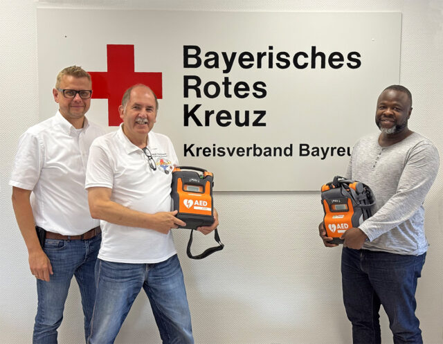 Seit 30 Jahren engagiert sich der BRK-Kreisverband Bayreuth für die Förderung der Kenntnisse der Bevölkerung in der Frühdefibrillation - in der Heimat und nun auch international. Das Projekt der Integrierten Leitstelle (ILS) Bayreuth/Kulmbach übergibt zwei Automatische Elektrische Defibrillatoren (AED) an Integrationsbeauftragter der Stadt Bayreuth Ibukun Koussemou (r.), für Krankenhäuser in Benin. Seit 20 Jahren engagiert sich der BRK-Kreisverband Bayreuth in Sachen Frühdefibrillation Im Bild (vl.n.r.): Markus Ruckdeschel (Kreisgeschäftsführer BRK-Bayreuth), Karl Bernet (ehrenamtlicher Projektkoordinator Defi-Netzwerk-Bayreuth) und Ibukun Koussemou (Integrationsbeauftragter der Stadt Bayreuth). Foto: BRK-Bayreuth.