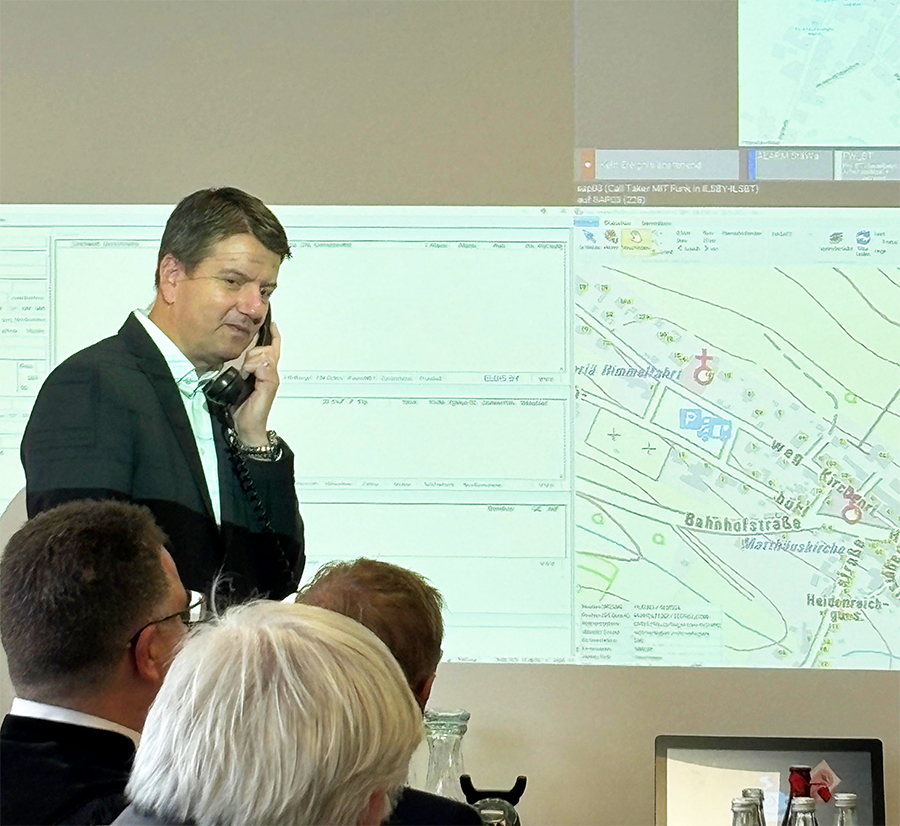 StSekr. Bay StMI Sandro Kirchner als Notrufer mit einem Telefon aus den 1920er Jahren.