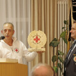 Die Kameraden der BRK-Bereitschaft Mehlmeisel übergeben anlässlich des 100-jährigen Jubiläums eine Holzuhr.