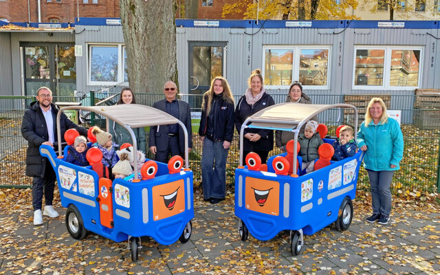 Zwei gespendete Kinderbusse für bis zu 6 Kinder in den Farben der VR Bank Bayreuth-Hof vor dem BRK-Kindernest. Mit im BIld Marcel Knie (Regionalleiter Kundenservice Süd der VR Bank Bayreuth-Hof), Maria Merkel (BRK-Kindernest), Peter Herzing (Vorsitzender BRK-Kreisverband Bayreuth), Susanne Bühner (Abteilungsleiterin Wohlfahrt & Soziales BRK-Kreisverband Bayreuth), Stefanie Ermer (Fachbereichsleiterin BRK-Kitas Bayreuth), Hediye Döner (BRK-Kinderhaus) und Nicole Meisner (BRK-Kindernest) und Kinder aus beiden Einrichtungen.