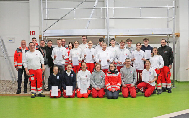 "SanBox"-Ausbildung 2025 - Gruppenbild. Im Bild: Die 14 neuen Sanitäterinnen und Sanitäter, das Team der Ausbilderinnen und Ausbilder um Oliver Heinz, Bernd Neukam (BRK-Kreisbereitschaftsleiter Bayreuth) und seine Stellvertreter Mischa Nietfeld und Patrick Czekalla, Dr. Christian Birnmeyer (BRK-Chefarzt Bayreuth) und Tanja Peplau (stv. technische Leiterin Kreiswasserwacht Bayreuth).