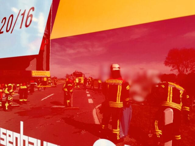 Spiegelung der Einsatzkräfta am Einsatzort in der Tür eines Feuerweheinsatzfahrzeuge.