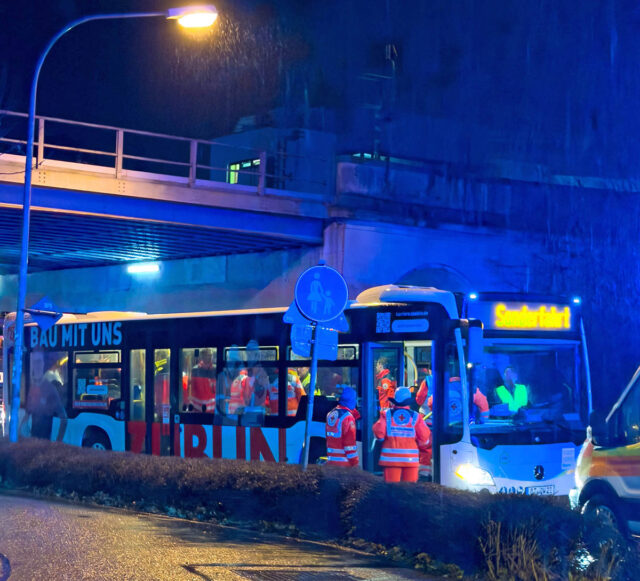 Einsatzkräfte und Verletzte und Betroffene des Zugunglücks am Bayreuther Hauptbahnhof werden in einem Bus transportiert.