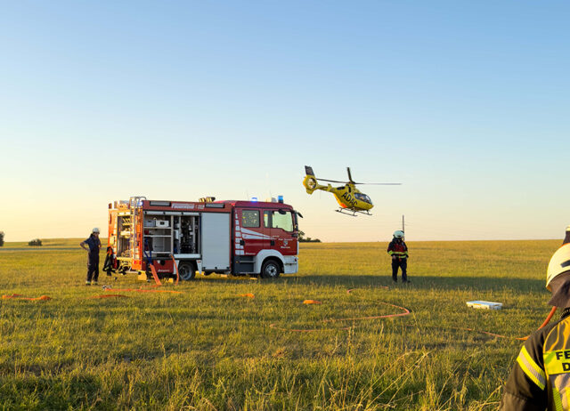 Rettungshubschrauber Christoph 20 am Einsatzort. Im Vordergrund Einsatzkräfte der Feuerwehr.
