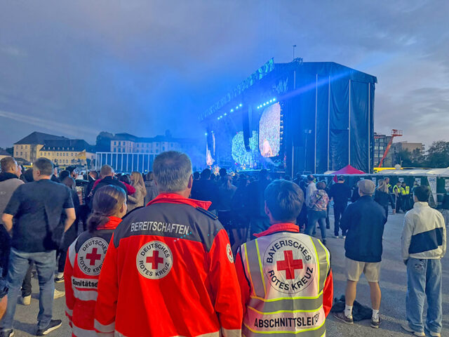 Ehrenamtliche des BRKs bei der Absicherung des Konzertes der Toten Hosen in Bayreuth - September 2026. Im Hintergrund die Bühne.